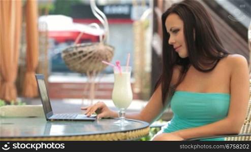 Beautiful Young woman Using Laptop at Outdoor Cafe