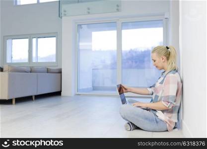 beautiful young woman using laptop computer on the floor at home