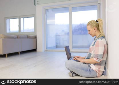 beautiful young woman using laptop computer on the floor at home