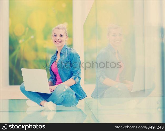 beautiful young woman using laptop computer on the floor at home. young woman using laptop computer on the floor