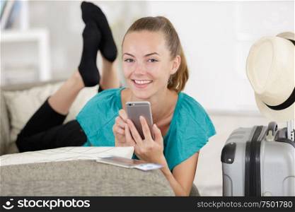 beautiful young woman using mobile phone on sofa