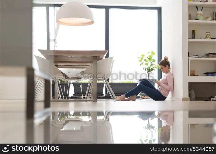 beautiful young woman using tablet computer on the floor at home