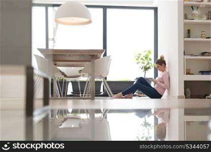 beautiful young woman using tablet computer on the floor at home