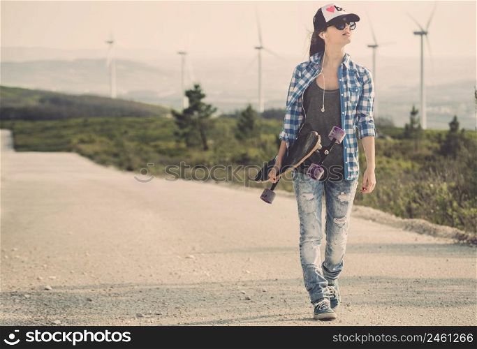 Beautiful Young woman walking and holding a skateboard