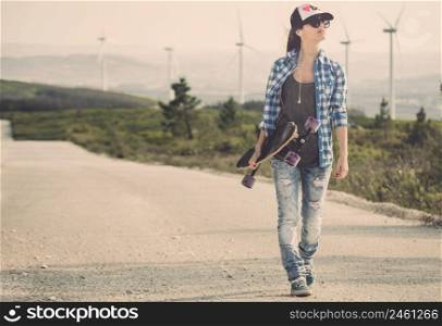 Beautiful Young woman walking and holding a skateboard
