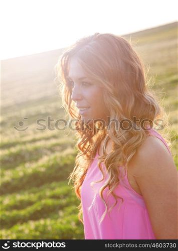 Beautiful young woman walking in the countryside with beautiful light