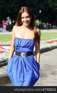 Beautiful young woman walking on the summer park