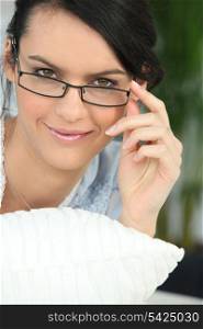 beautiful young woman watching over her glasses