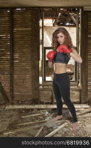 Beautiful young woman wearing a pair of boxing gloves