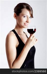 Beautiful young woman wearing a sexy evening dress and drinking  a wineglass 
