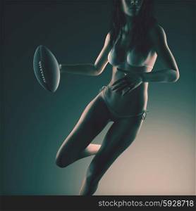 Beautiful young woman wearing bikini holding football