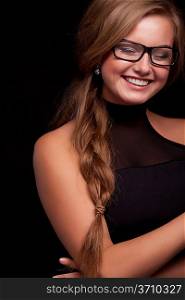 Beautiful young woman wearing glasses, smiling on black background
