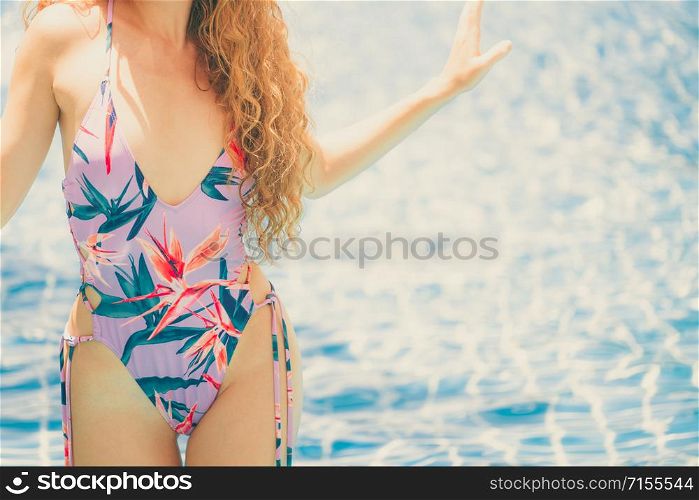 Beautiful young woman wearing swimsuit is on summer vacation. Travel and lifestyle.. Happy young woman in swimsuit at swimming pool.