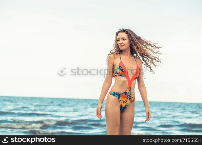 Beautiful young woman wearing swimsuit is on summer vacation. Travel and lifestyle.. Happy young woman at beach in summer vacation.