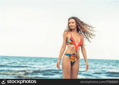 Beautiful young woman wearing swimsuit is on summer vacation. Travel and lifestyle.. Happy young woman at beach in summer vacation.