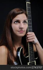 beautiful young woman with a black guitar in his hand. Isolated on white background