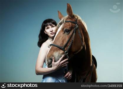 Beautiful young woman with a brown horse