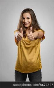 Beautiful young woman with a great smile with thumbs up