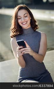 Beautiful young woman with a smartphone in an office building