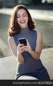 Beautiful young woman with a smartphone in an office building