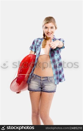Beautiful young woman with a surfboard, over a gray background