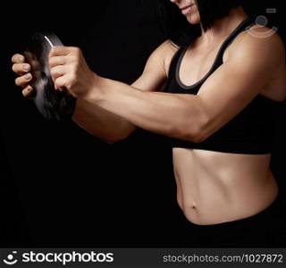 beautiful young woman with black hair and a sports figure holds a steel circle for sports, low key