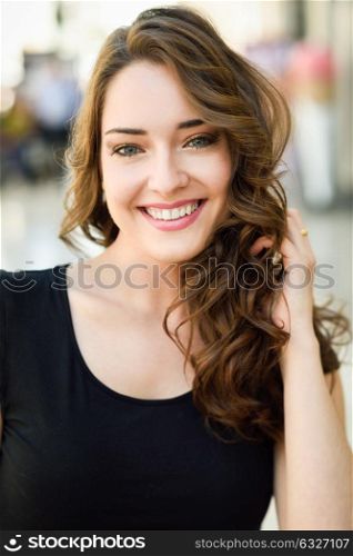 Beautiful young woman with blue eyes smiling in urban background. Girl wearing summer clothes