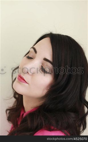 Beautiful young woman with brown hair and eyes closed