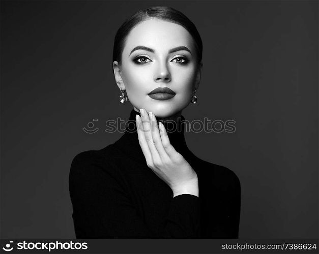 Beautiful Young Woman with Clean Fresh Skin. Perfect Makeup. Beauty Fashion. Plump Lips. Cosmetic Eyeshadow. Smooth Hair. Girl in Black Turtleneck. Black and white photo
