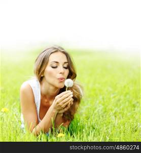 beautiful young woman with dandelion. beautiful young woman with dandelion lying on grass
