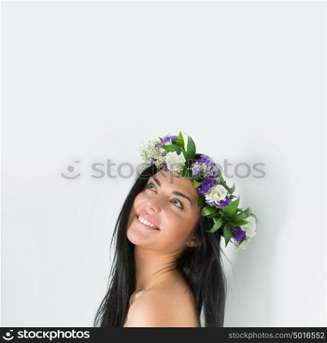 Beautiful young woman with delicate flowers in her hair. Copyspace overhead