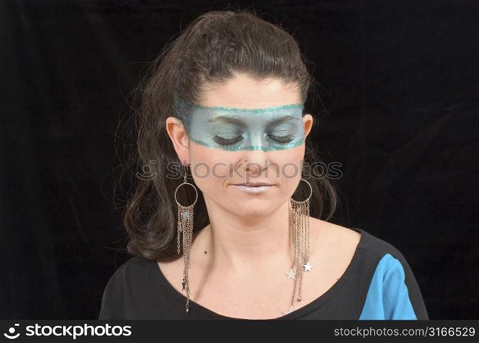 Beautiful young woman with extreme makeup over black