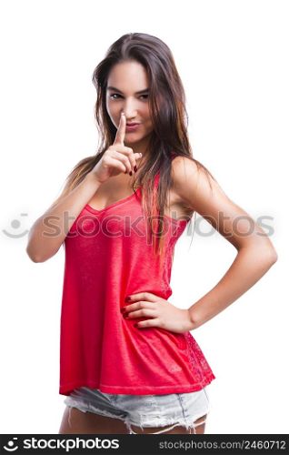 Beautiful young woman with finger in front of mouth, asking to make less noise, isolated over white