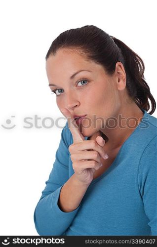 Beautiful young woman with finger on lips on white background