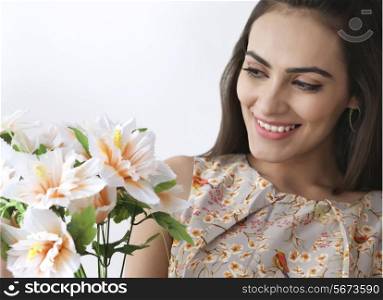 Beautiful young woman with flowers over white background