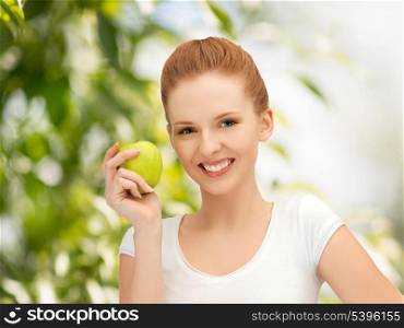 beautiful young woman with green apple at countryside