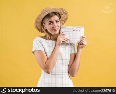 beautiful young woman with hat holding period calendar