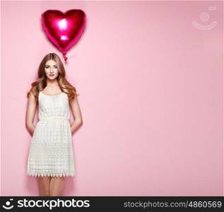 Beautiful young woman with heart shape air balloon on color background. Woman on Valentine's Day. Symbol of love