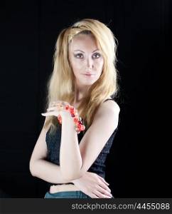 beautiful young woman with long blonde hair and a red bracelet on a dark background
