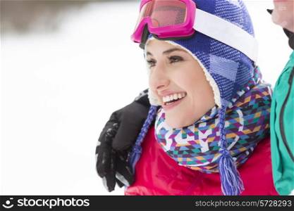 Beautiful young woman with male friend looking away in winter