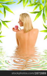 Beautiful young woman with orchid flower reflected in rendered water