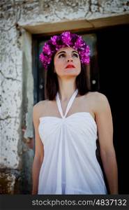 Beautiful Young Woman with Pink Flowers and White dress. Long Brunette Hair and Fashion Makeup