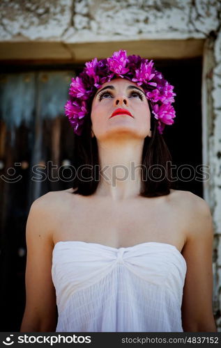 Beautiful Young Woman with Pink Flowers and White dress. Long Brunette Hair and Fashion Makeup