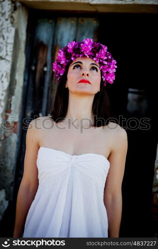 Beautiful Young Woman with Pink Flowers and White dress. Long Brunette Hair and Fashion Makeup
