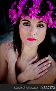 Beautiful Young Woman with Pink Flowers. Long Brunette Hair and Fashion Makeup