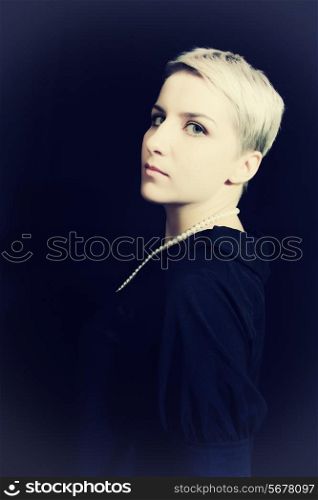 Beautiful young woman with short hair on black background