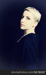 Beautiful young woman with short hair on black background
