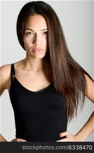 Beautiful young woman without make-up. Beautiful girl with green eyes, model of fashion wearing black tank top on white background.