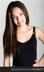 Beautiful young woman without make-up smiling. Beautiful girl with green eyes, model of fashion wearing black tank top on white background.
