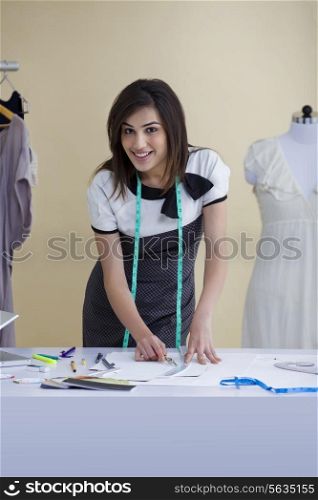 Beautiful young woman working in fashion studio